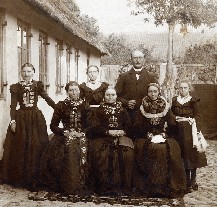 Peter Raagaard med sin familie i amagerdragter foran gården. Foto ca. 1905.