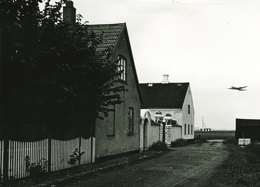 Hjørnegård med et fly i baggrunden. 1971. Foto: Vagn Jacobsen.